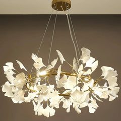 Modern gold chandelier with white gingko leaf-shaped lights suspended from ceiling