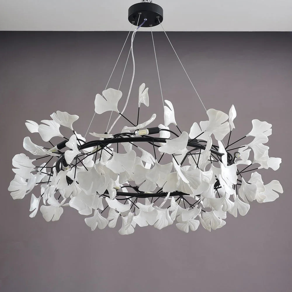 Modern chandelier pendant lamp with white ginkgo leaf design on black rings, suspended by cables