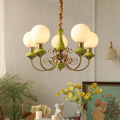 Modern five-light chandelier with gold and green accents, globe lampshades, elegant home decor setting