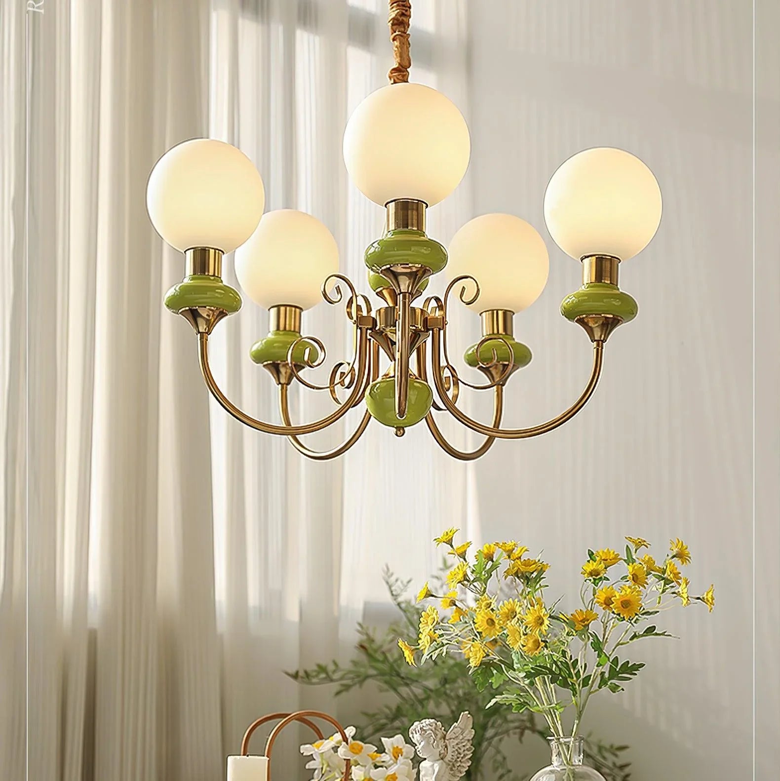 Modern 5-light chandelier with gold and green accents, frosted glass globes over dining table with flowers
