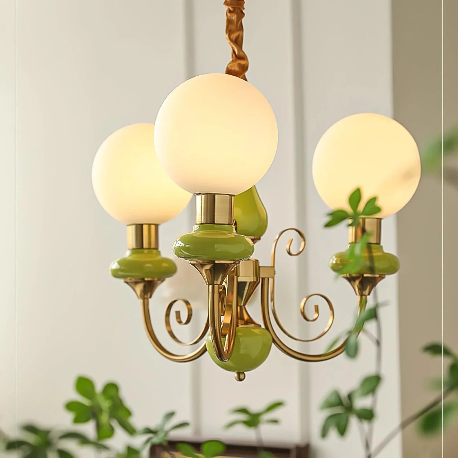 Modern 3-head chandelier with gold metal and green accents, featuring round white glass globes