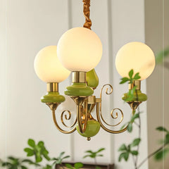 Modern 3-head chandelier with gold metal and green accents, featuring round white glass globes