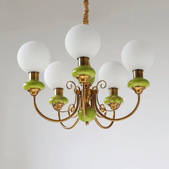 Modern chandelier with five white globe lights, gold metal arms, and green decorative accents