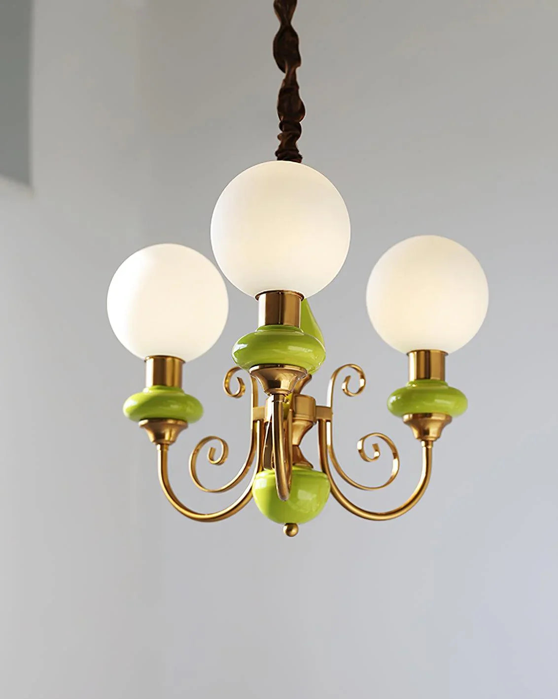 Modern three-head chandelier with frosted glass globes, gold metal frame and green accents by YH Lamps
