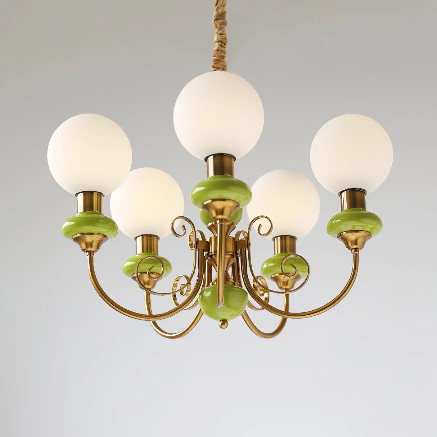Modern chandelier with five white globe lights, gold metal arms, and green ceramic accents