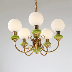 Modern chandelier with five white globe lights, gold metal arms, and green ceramic accents