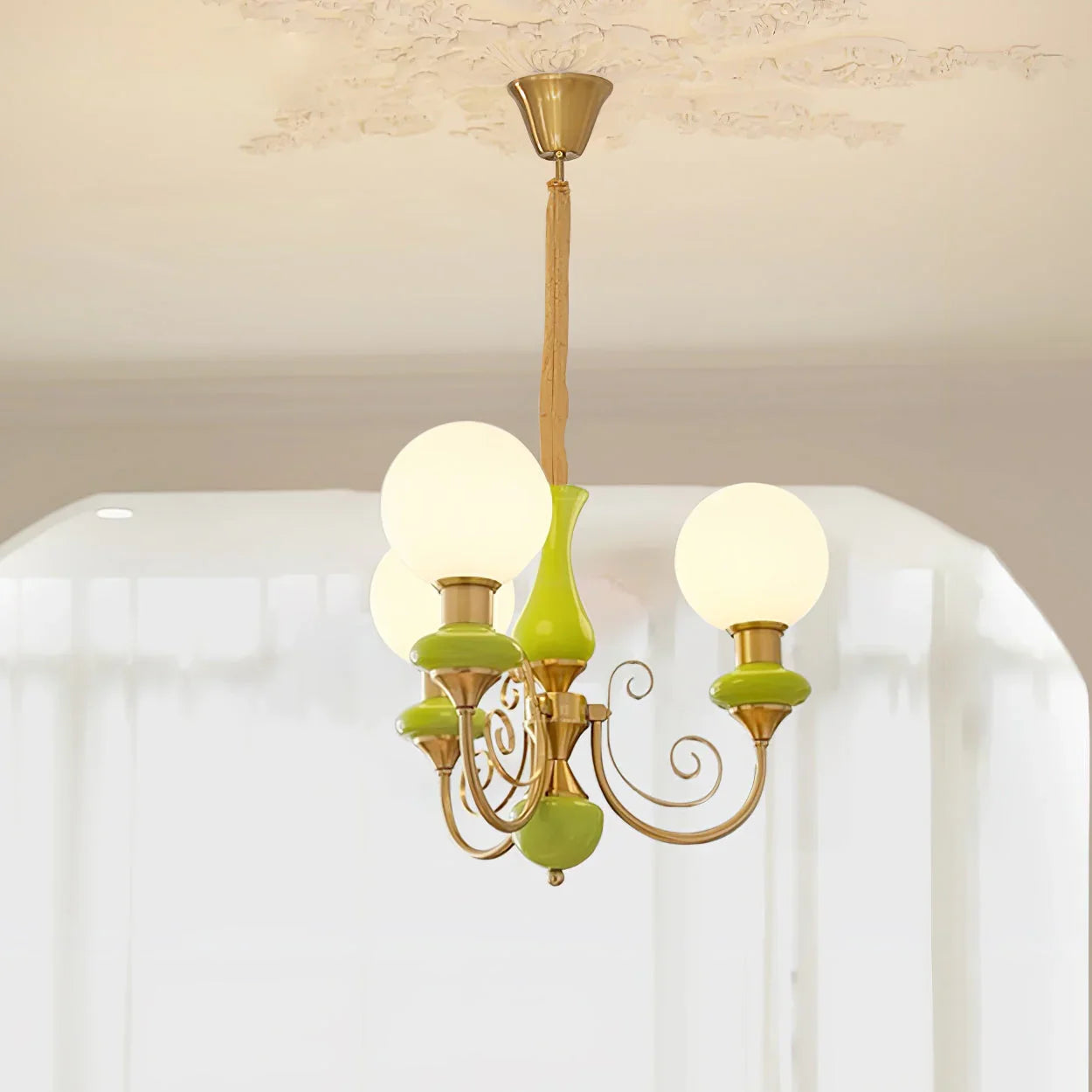 Modern chandelier pendant lamp with three white globe lights, gold metal frame, and green accents