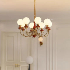 Elegant nine-light chandelier with gold and red accents and white glass globes in a classic interior