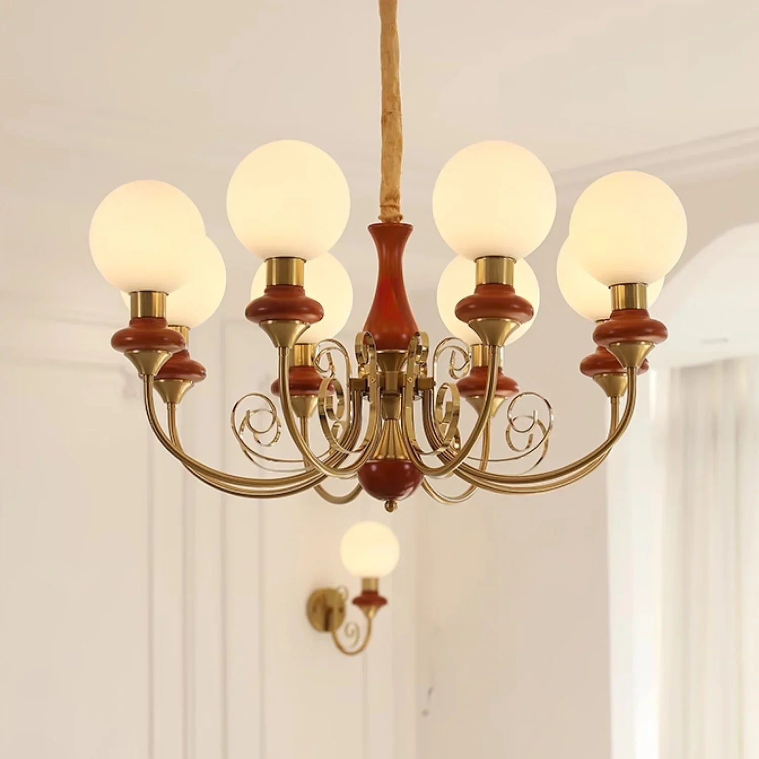 Elegant six-light chandelier with brass and wood accents, frosted white globe shades, modern home lighting