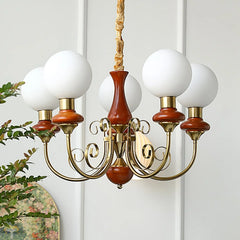 Modern chandelier with five white globe lamps, brass arms, and wooden accents in elegant home setting