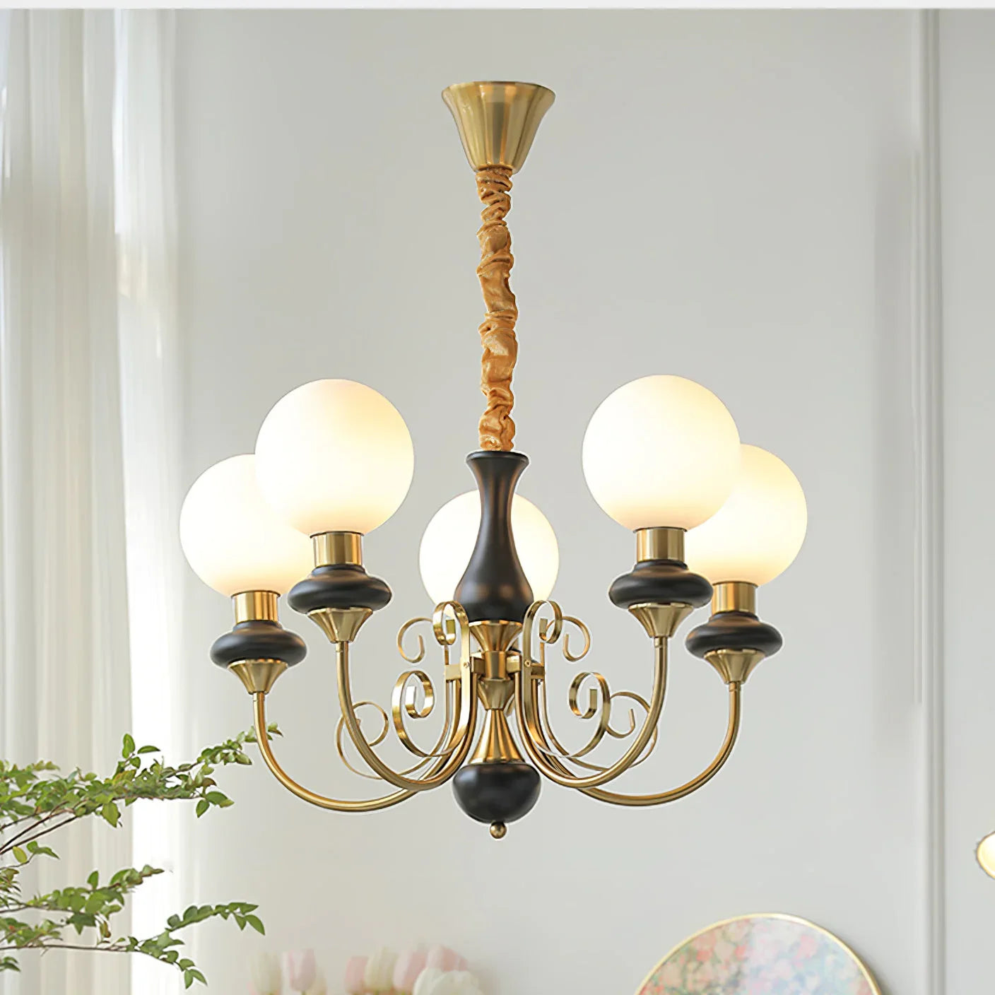 Modern chandelier with six frosted glass globes, gold and black metal arms, hanging in a bright room