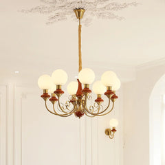 Modern 3-head chandelier with gold and brown metal arms and white globe lamps in elegant room