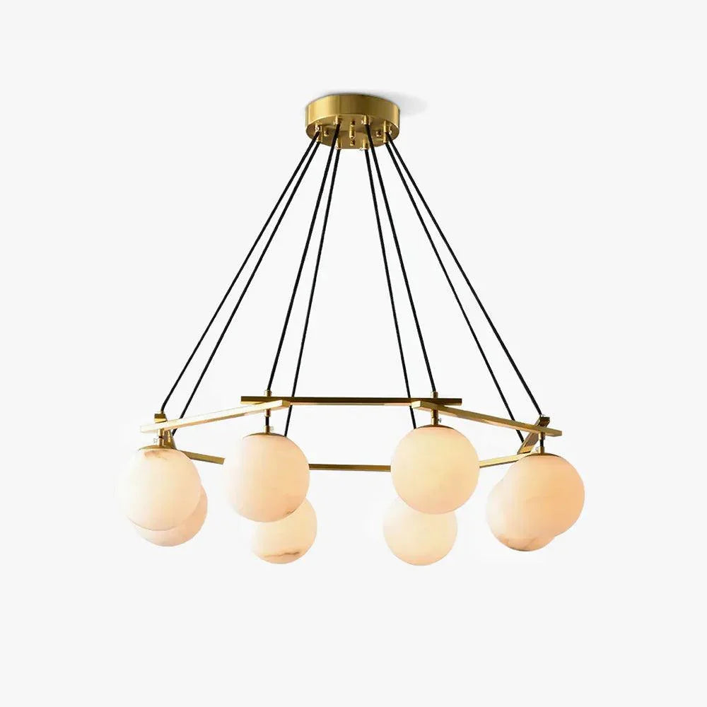 Modern brass chandelier with six alabaster globe pendant lights hanging from black cords in a circular design
