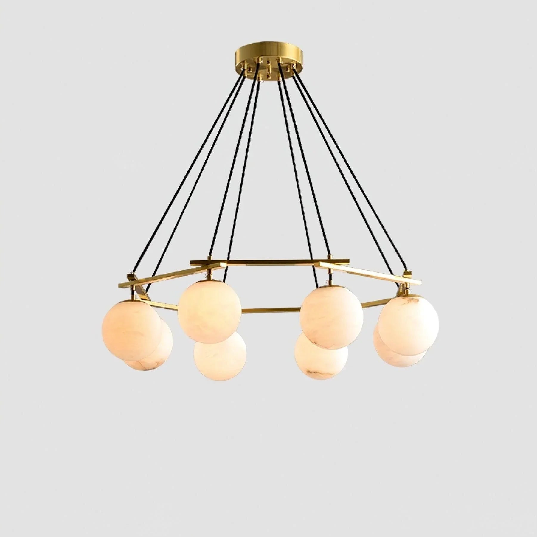 Modern chandelier pendant lamp with six white alabaster globe shades and brass frame suspended by black cords