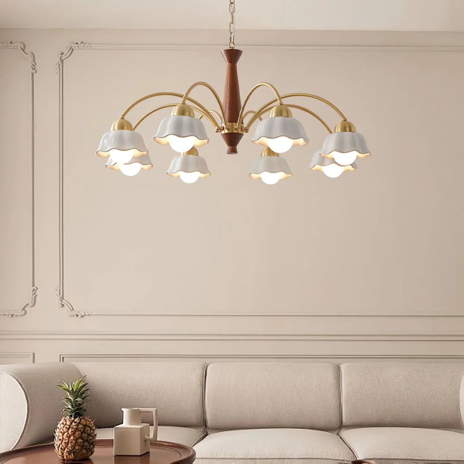 Swedish modern brass chandelier with nine white flower-shaped lampshades hanging over beige sofa in elegant living room