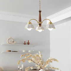 Modern 3-head brass and walnut wood pendant chandelier with white petal-shaped shades in minimalist room