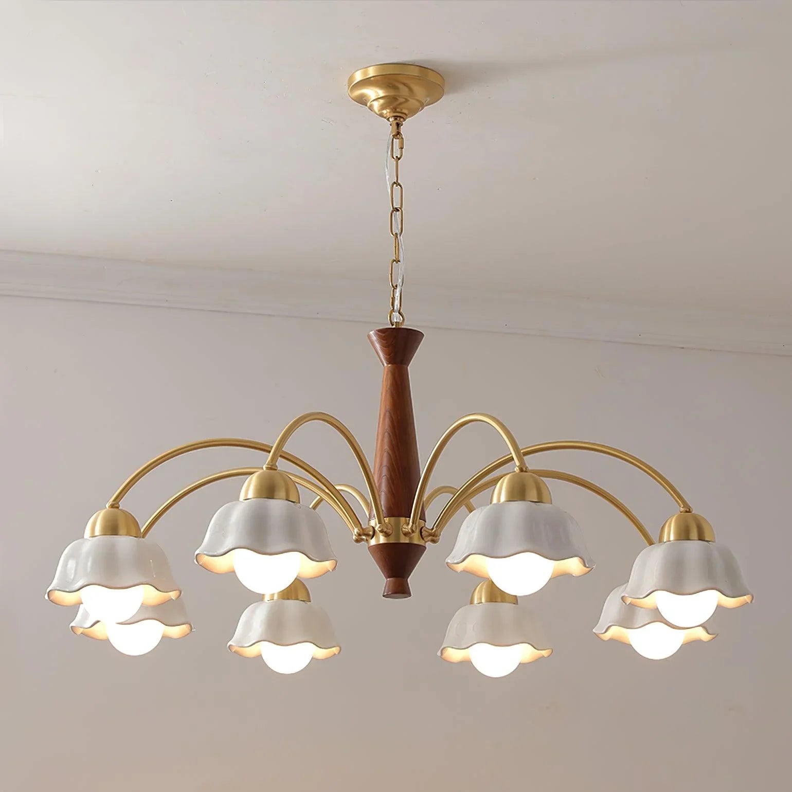 Modern chandelier with 3 white glass shades on brass arms and walnut wood center, ceiling mounted