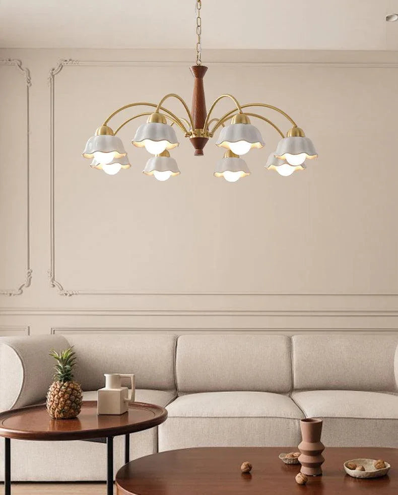 Swedish modern chandelier with brass and walnut wood, nine white flower-shaped pendant lights over beige sofa