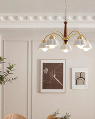 Modern brass and walnut wood chandelier with six petal-shaped white shades in a minimalist living room