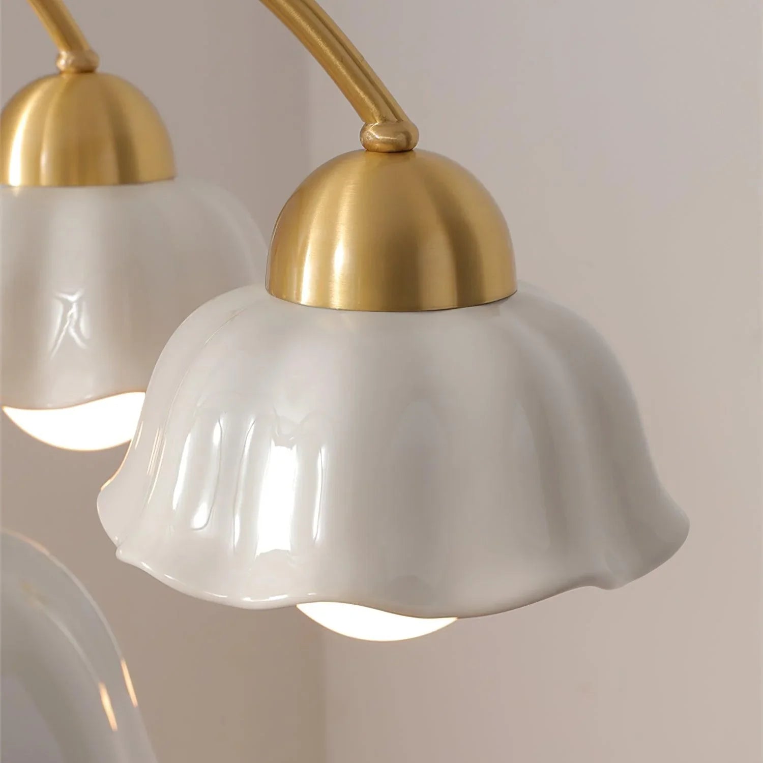 Close-up of modern pendant lamp with white scalloped glass shade and brass fixture against beige wall