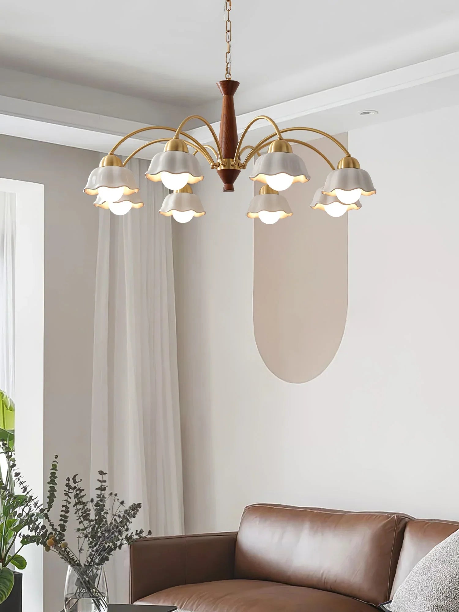 Modern brass and walnut wood chandelier with eight white flower-shaped lampshades over living room sofa