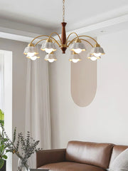 Modern brass and walnut wood chandelier with eight white flower-shaped lampshades over living room sofa