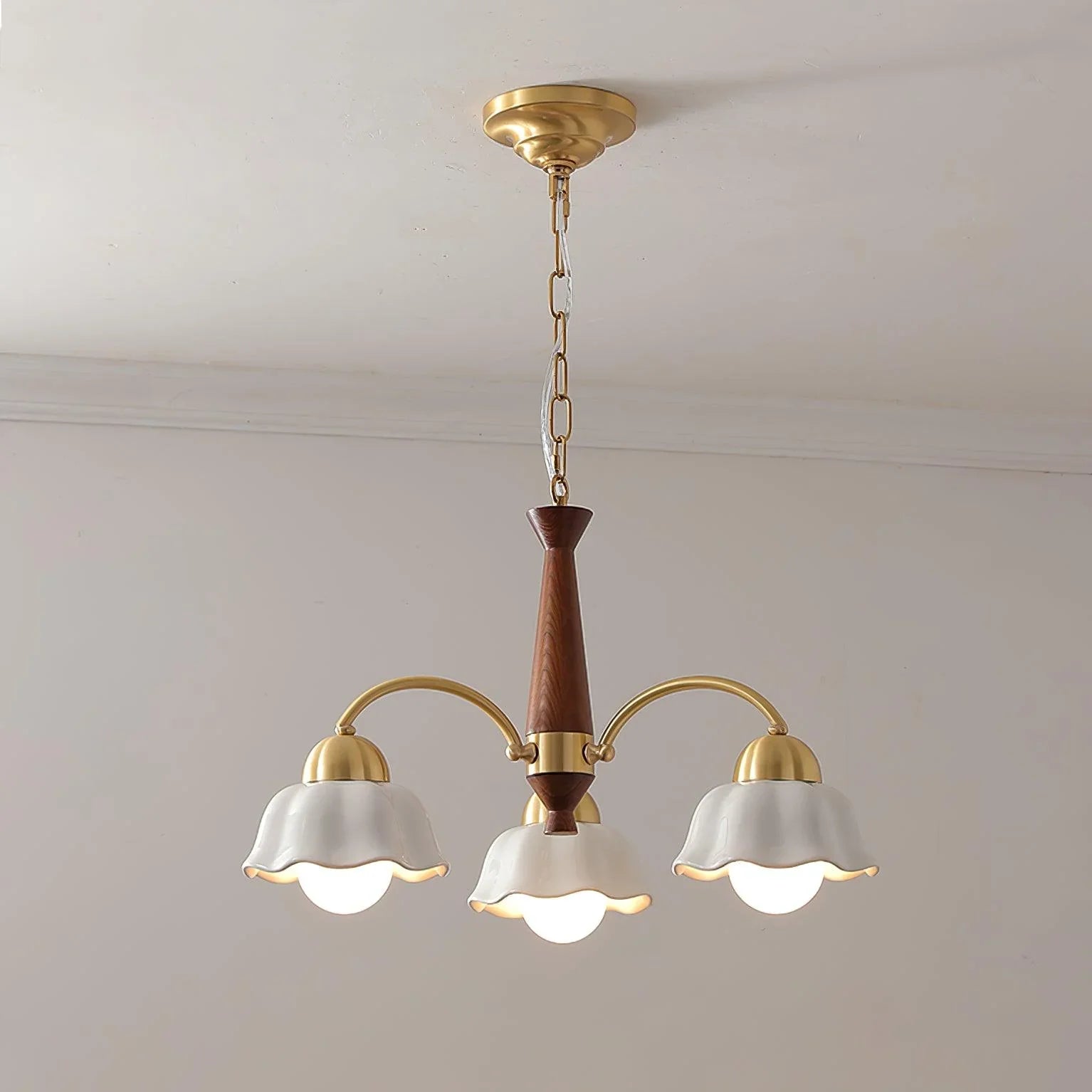 Modern 3-head brass chandelier with white flower-shaped shades and walnut wood details