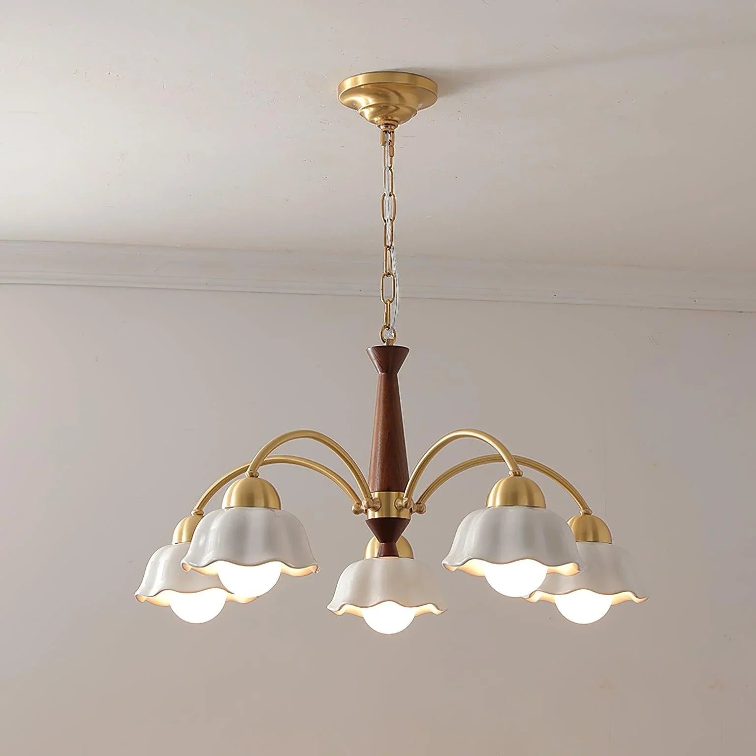 Modern Swedish chandelier pendant lamp with five white scalloped shades, brass arms, and walnut wood center