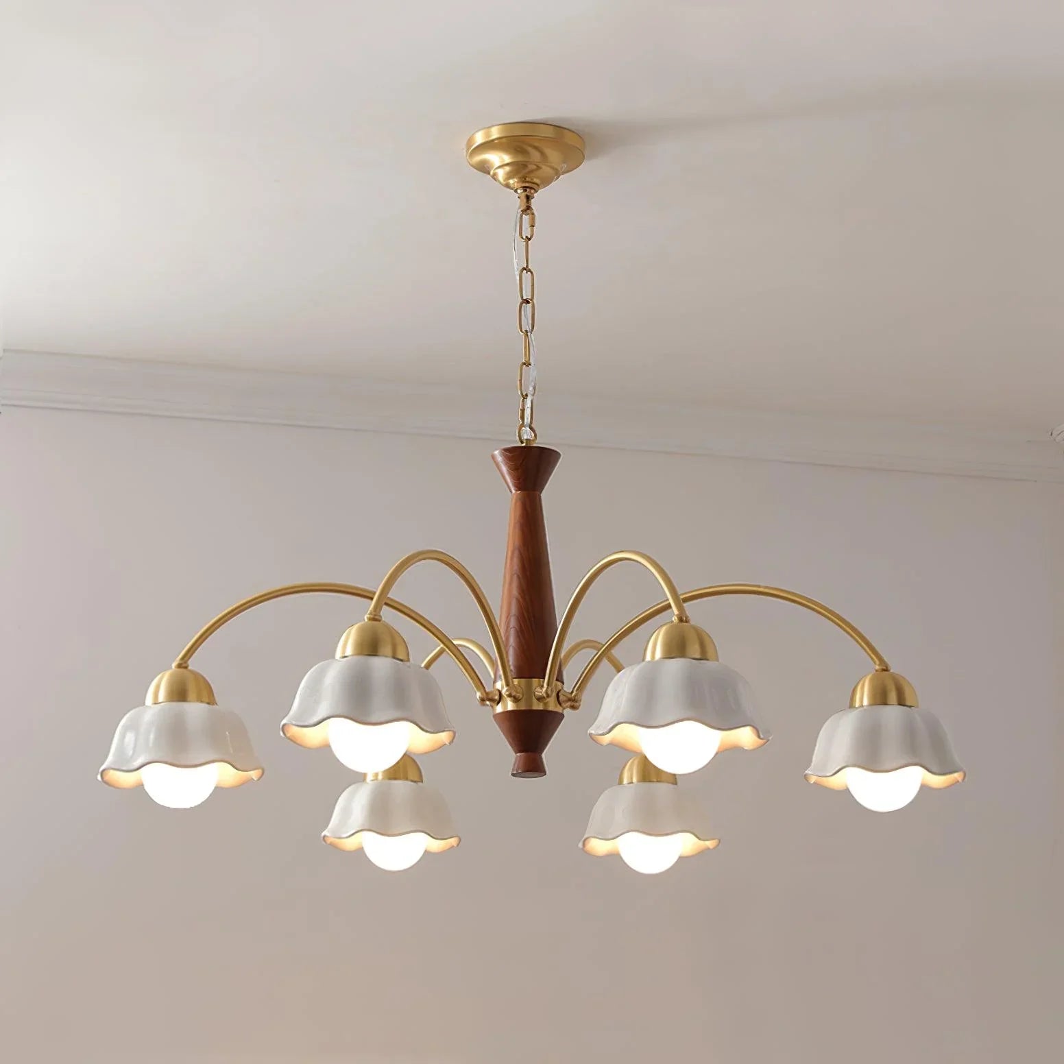 Modern 6-light brass chandelier with white petal-shaped shades and walnut wood center hanging from ceiling
