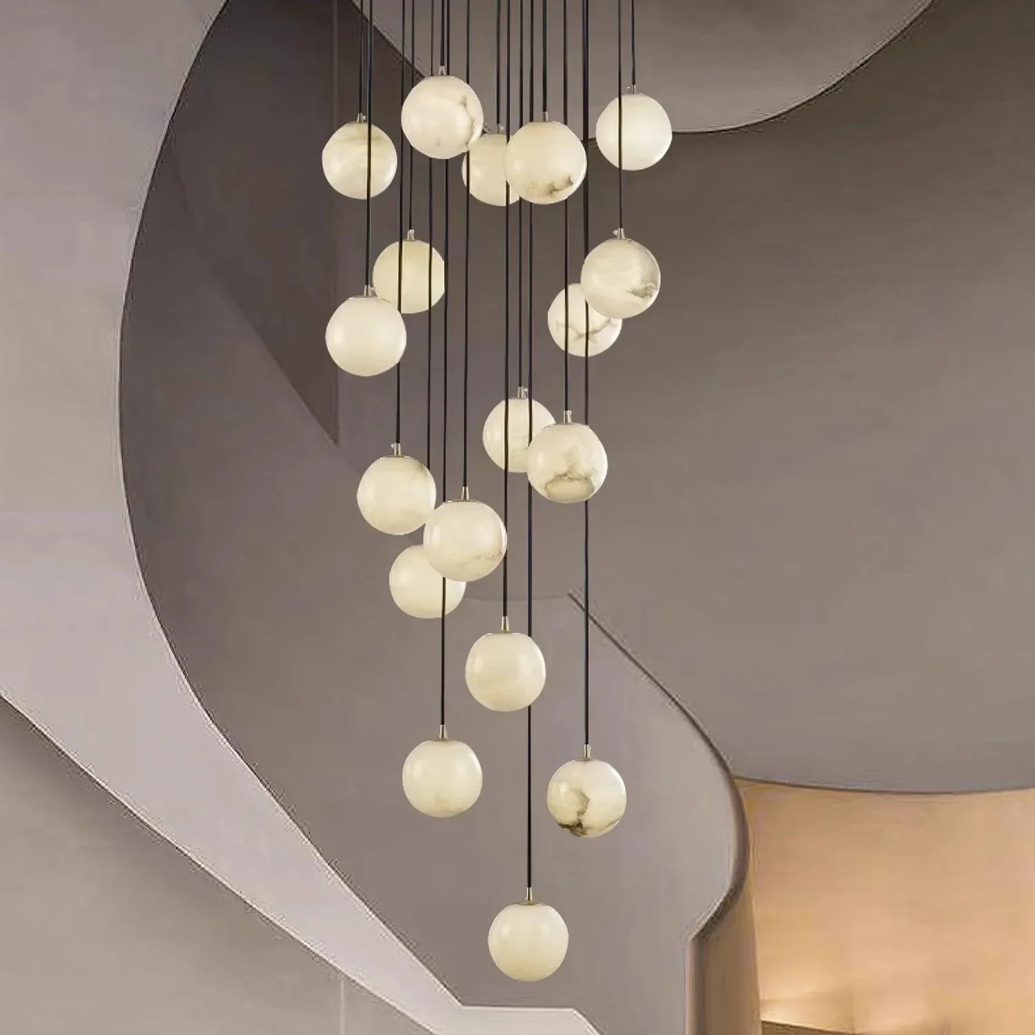 Modern multi-globe chandelier with alabaster ball pendants hanging in minimalist interior