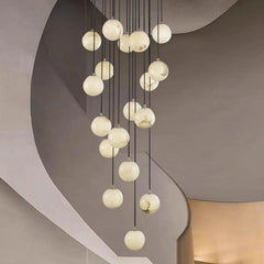 Modern multi-globe chandelier with alabaster ball pendants hanging in minimalist interior
