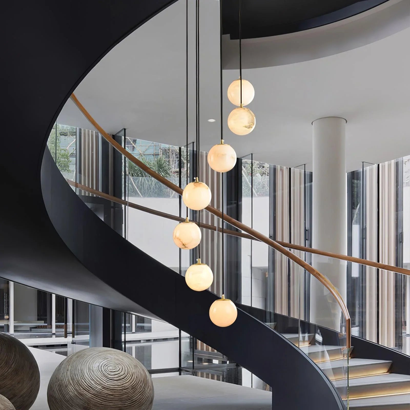 Modern hanging chandelier with alabaster globe lights arranged vertically in a spiral staircase feature
