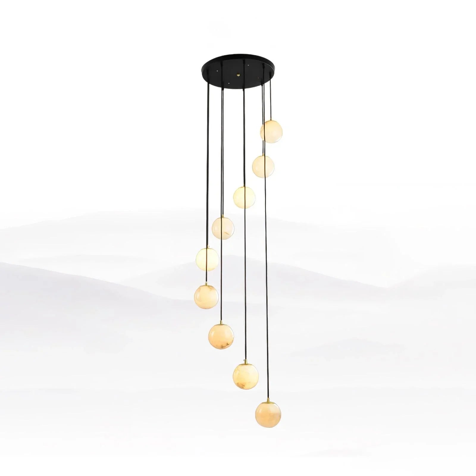 Modern pendant chandelier with nine alabaster glass globe lights hanging in staggered lengths from a black round ceiling canopy