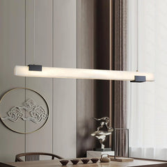 Modern pendant lamp with alabaster-style light and black accents hanging over wooden dining table in minimalist interior