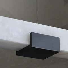 Modern black and white rectangular pendant lamp with warm light hanging from ceiling