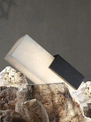 Modern black and white rectangular pendant lamp with warm alabaster light on stone background
