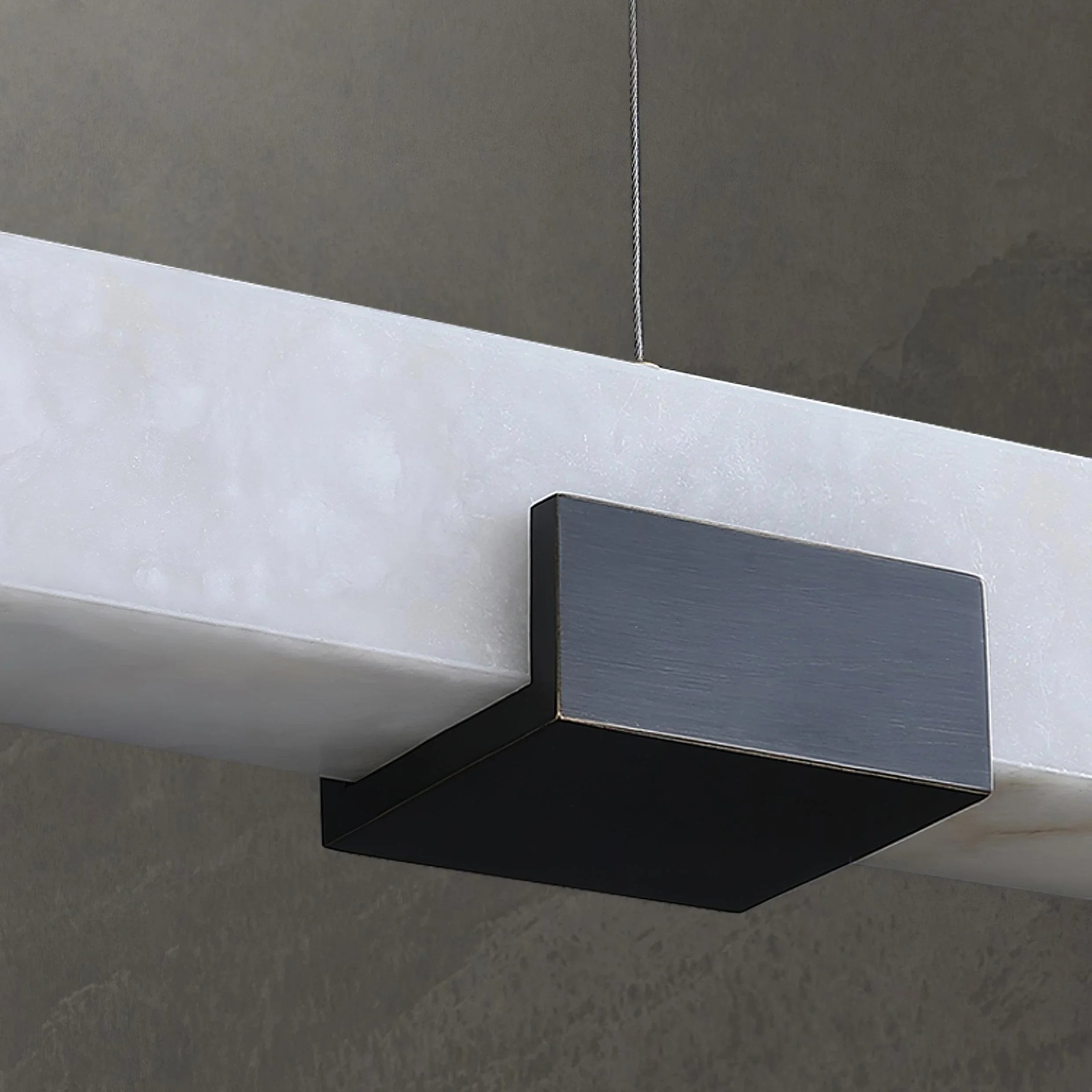 Modern black and white rectangular pendant chandelier with warm light, hanging from ceiling