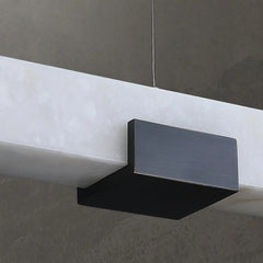 Modern black and white rectangular pendant chandelier with warm light, hanging from ceiling