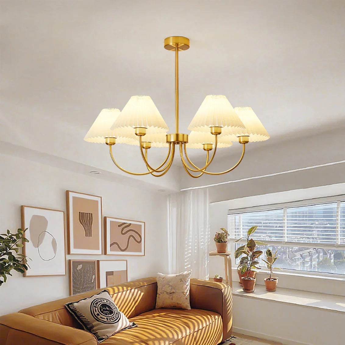 Modern brass and white 4-head chandelier over a cozy living room with wall art and sofa
