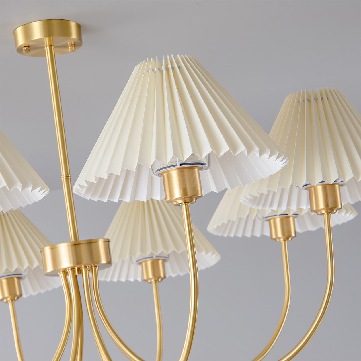 Modern brass chandelier with four pleated white lampshades from YH Lamps