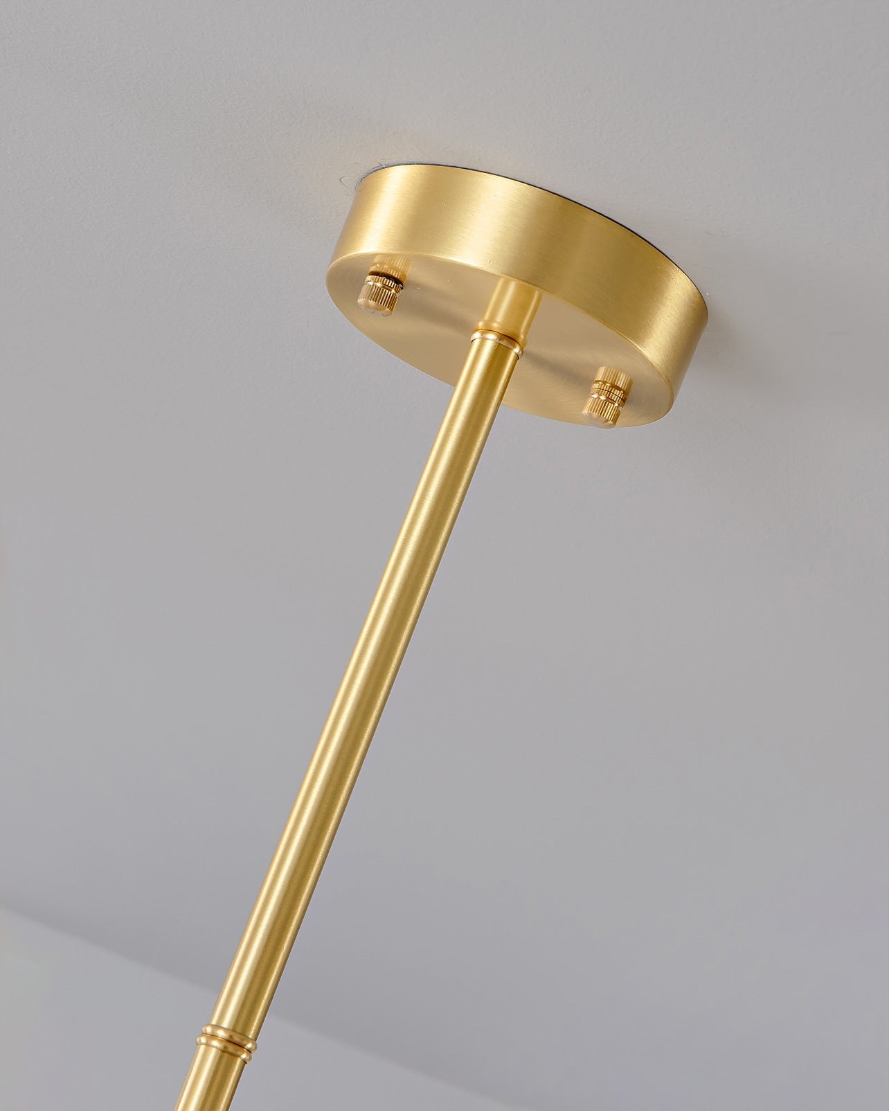 Close-up of a modern brass ceiling canopy and rod for YH Lamps pendant chandelier