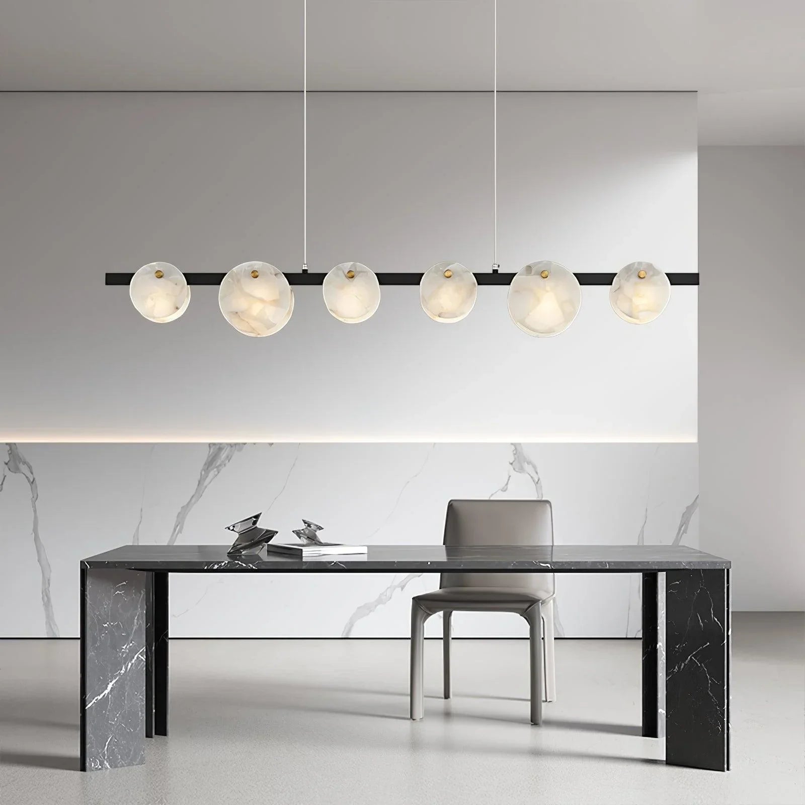 Modern dining room with black marble table, gray chair, and linear pendant chandelier with six round white glass lights