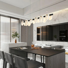 Modern dining room with black table, leather chairs, and long pendant chandelier with white brass lamps at YH Lamps