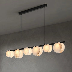 Modern linear pendant chandelier with round alabaster stone shades and black metal frame on gray ceiling