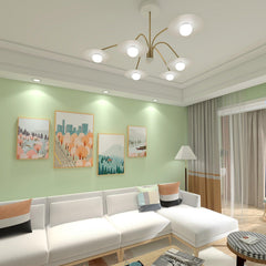 Modern living room with six-head gold and white chandelier, sectional sofa, green walls and framed art
