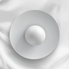 Modern white circular pendant lamp with smooth layered design against white fabric background