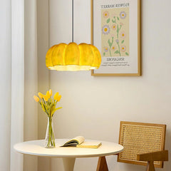 Yellow pumpkin-shaped pendant lamp chandelier above a round table with flowers, modern home decor from YH Lamps.