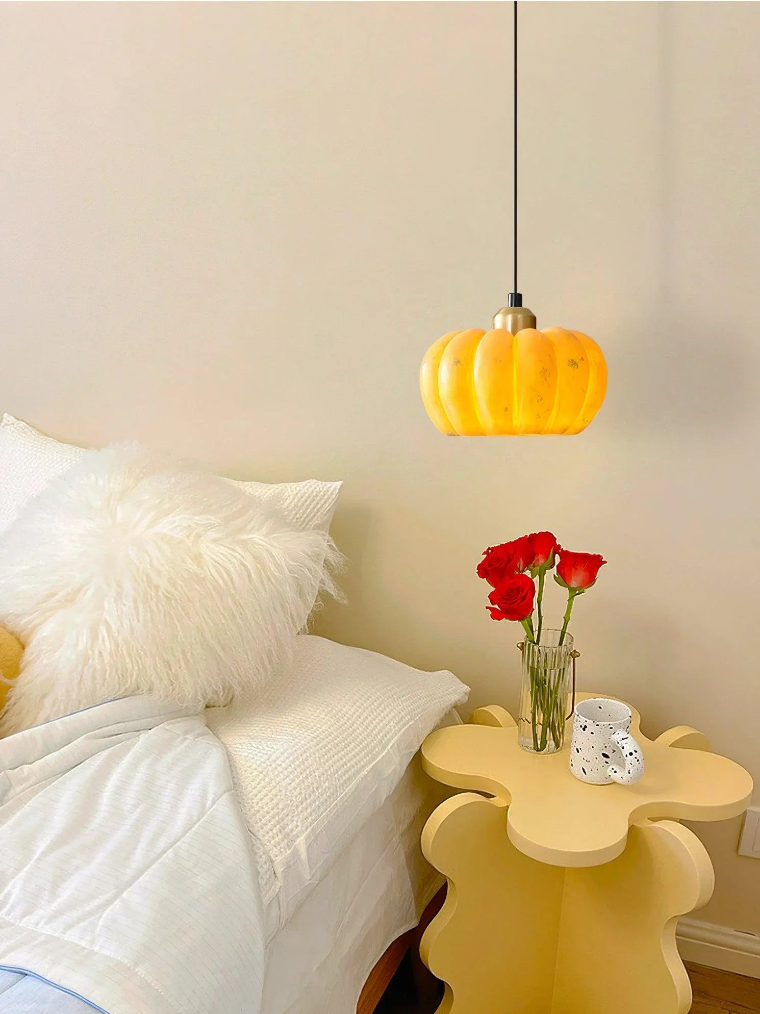 Yellow pumpkin pendant lamp above modern bedside table with red roses at YH Lamps