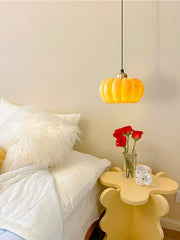 Yellow pumpkin pendant lamp above modern bedside table with red roses at YH Lamps