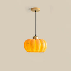 Modern yellow pumpkin-shaped pendant lamp with brass accent from YH Lamps on beige background